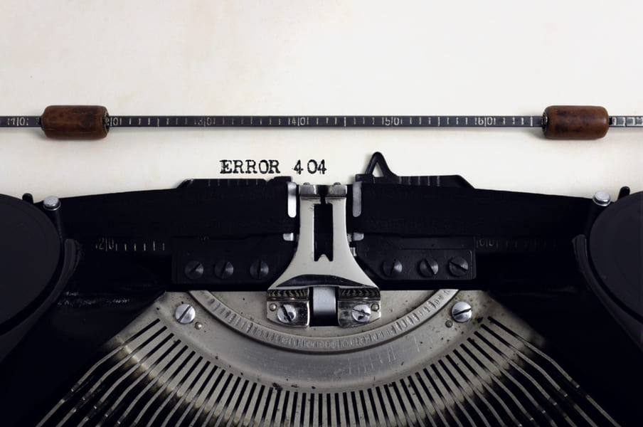 Old retro vintage black typewriter with close-up typing text Error 404 as heading on aged paper